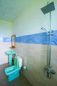 W łazience znajduje się niebieska toaleta i prysznic. w obiekcie Casa Ninearch Villa w mieście Ella