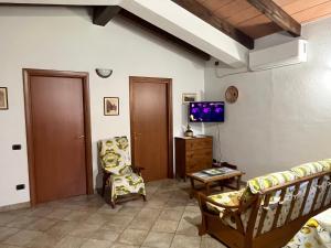 a living room with a couch and a tv at Casa Costera in Orosei