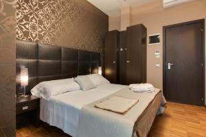 una camera con un grande letto con testiera nera di Atmosfere Milano Marittima a Milano Marittima