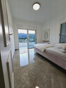a bedroom with a large bed and a large window at הבית הלבן in Qiryat Shemona