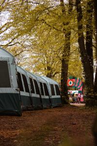 eine Reihe von Zelten in einem Park mit Bäumen in der Unterkunft Oktoberfest and Springfest Inclusive Camping in München