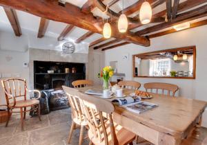 阿斯科里格的住宿－Rooks Cottage，厨房以及带木桌和椅子的用餐室。