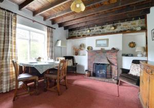 a living room with a table and a fireplace at Rockley Cottage in Egton