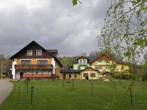 a group of houses in a grassy field with a building at Penzion u Petra in Jeseník