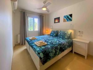 Schlafzimmer mit einem Bett mit blauer Decke in der Unterkunft Bon Dia Albir in Albir
