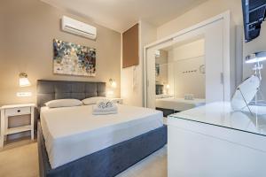 1 Schlafzimmer mit einem großen Bett und einem Badezimmer in der Unterkunft Elounda Helios Luxury Apartment with Rooftop Jacuzzi in Elounda