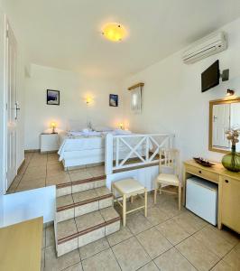 una camera con letto, scrivania e letto di Horizon Hotel a Chora Folegandros