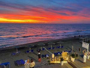 阿齊歐斯·貢多斯的住宿－Romantic Palace Beach Apartments，一群人,在日落时站在海滩上