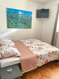1 dormitorio con 1 cama y TV de pantalla plana en Two Stars Apartment en Podstrana