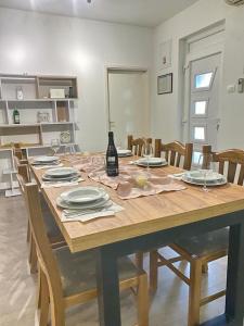 - une table en bois avec des assiettes et une bouteille de vin dans l'établissement Two Stars Apartment, à Podstrana