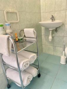 La salle de bains est pourvue d'un lavabo et d'une voiturette avec des serviettes. dans l'établissement Two Stars Apartment, à Podstrana