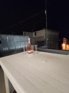 een fles wijn zittend op een tafel met twee glazen bij Affittacamere Girasole in Modugno