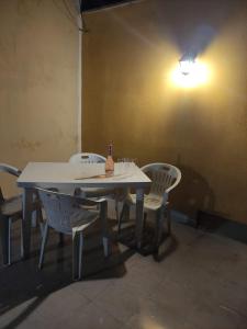 莫杜尼奧的住宿－Affittacamere Girasole，一张白色的桌子和椅子,上面有一瓶葡萄酒