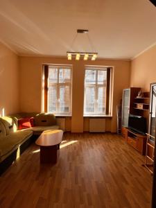 een woonkamer met een bank en een tv bij Apartaments near Ploshcha Rynok in Lviv