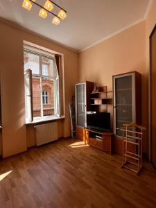 an empty living room with a television and a window at Apartaments near Ploshcha Rynok in Lviv