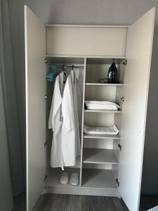 a walk in closet with white towels and shoes at Chikhi in Tbilisi City
