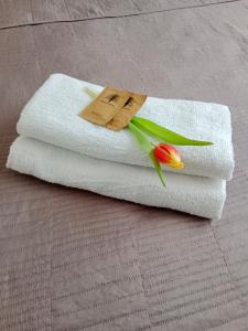 a towel with a flower on it with a tag on it at Apartament Glamour Chełm in Chełm