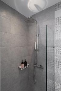 baño con ducha y puerta de cristal en AKRI Suites Vourvoulos, en Vourvoúlos