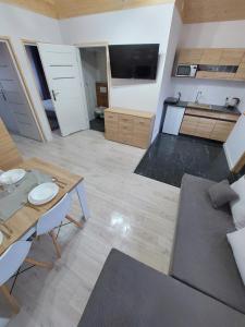 ein großes Wohnzimmer mit einem Tisch und einem Sofa in der Unterkunft Domki Letniskowe Family Dreams in Sarbinowo