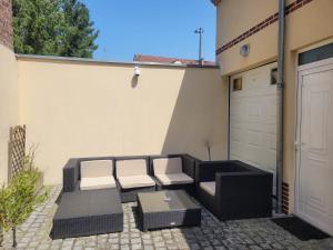 un patio avec deux chaises et une table ainsi qu'un garage dans l'établissement Studio chaleureux Beauvais-centre, gare et proche Aéroport, à Beauvais