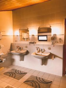 a public bathroom with two sinks and a microwave at Naturnahes Familienchalet mit Garten - Wifi - Netflix - nur 15 Minuten vom Chiemsee und 35 Minuten von München entfernt in Vogtareuth