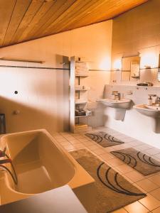 a large bathroom with a tub and two sinks at Naturnahes Familienchalet mit Garten - Wifi - Netflix - nur 15 Minuten vom Chiemsee und 35 Minuten von München entfernt in Vogtareuth