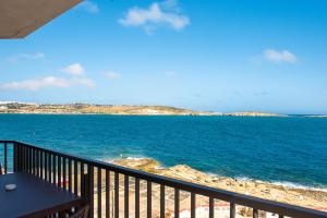 a view of the ocean from a balcony at Islet Promenade Seafront 1 Bedroom Apartment with 2 seaview balconies by Getawaysmalta in St Paul's Bay