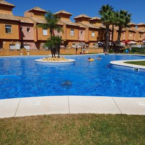 a swimming pool at a resort with people in it at Pinares de Lepe in Huelva +17 photos