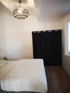 - une chambre avec un lit et une porte noire dans l'établissement Maisonnette 4 pers rez de jardin avec terrasse, au Cap d'Agde