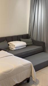a couch with two pillows on it in a room at Duck Duck House 3BR 7-11 PAX in Johor Bahru