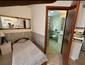 um pequeno quarto com uma cama e uma casa de banho em Reksor em Międzyzdroje