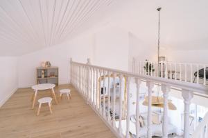 a white staircase with a table and chairs in a room at Noirmoutier Le Grand Large in LʼHerbaudière
