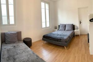 1 Schlafzimmer mit 2 Betten und 2 Fenstern in der Unterkunft Charming apartment - near Paris in Arcueil