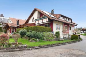 ein rotes und weißes Haus mit einem Garten in der Unterkunft Mutschler in Freudenstadt