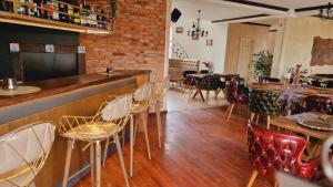 un bar avec des chaises et des tables dans un restaurant dans l'établissement Villa Westfalia Guest House, à Târgu Secuiesc