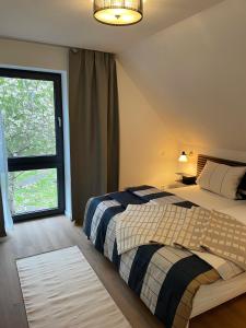 a bedroom with a bed and a large window at Backsteinquartier Rügen in Putbus