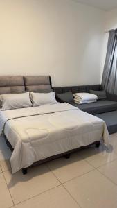 Cama grande en habitación con sofá en Duck Duck House 3BR 7-11 PAX, en Johor Bahru