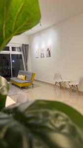 ein Wohnzimmer mit einem gelben Sofa und Stühlen in der Unterkunft Duck Duck House 3BR 7-11 PAX in Johor Bahru