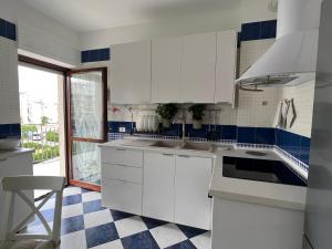 una cocina con armarios blancos y azulejos azules y blancos en Morada Azul, en Monopoli
