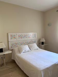 a bedroom with a large white bed and two tables at Apartamento Calle Nueva in Ronda