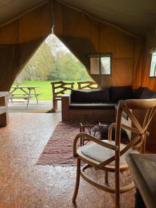 ein Wohnzimmer mit einer Couch und einem Sessel in der Unterkunft Tentes Safari aux Gîtes de Cormenin in Saint-Hilaire-sur-Puiseaux