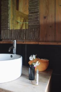 eine Badezimmertheke mit einem Waschbecken und einer Vase aus Blumen in der Unterkunft Tentes Safari aux Gîtes de Cormenin in Saint-Hilaire-sur-Puiseaux