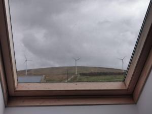 a window with a view of a wind farm at Cozy 6 Bedroom house with spectacular views in Belmullet