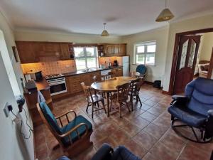 a kitchen and dining room with a table and chairs at Cozy 6 Bedroom house with spectacular views in Belmullet