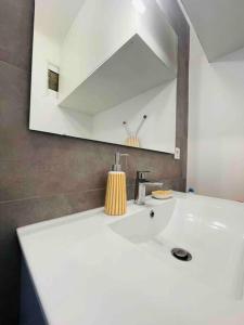 een badkamer met een witte wastafel en een spiegel bij Centre Cannes Martinez, Beau F2 avec terrasse in Cannes