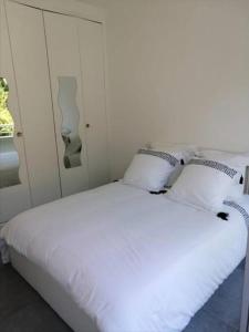 een wit bed met 2 kussens in een slaapkamer bij Centre Cannes Martinez, Beau F2 avec terrasse in Cannes