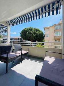 een balkon met stoelen en een pergola op een gebouw bij Centre Cannes Martinez, Beau F2 avec terrasse in Cannes