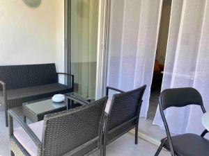 een woonkamer met een bank en een tafel en stoelen bij Centre Cannes Martinez, Beau F2 avec terrasse in Cannes