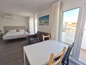 a living room with a bed and a couch and a table at Vila Alexandra in Costa da Caparica