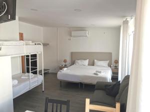 a bedroom with a bed and a bunk bed at Vila Alexandra in Costa da Caparica